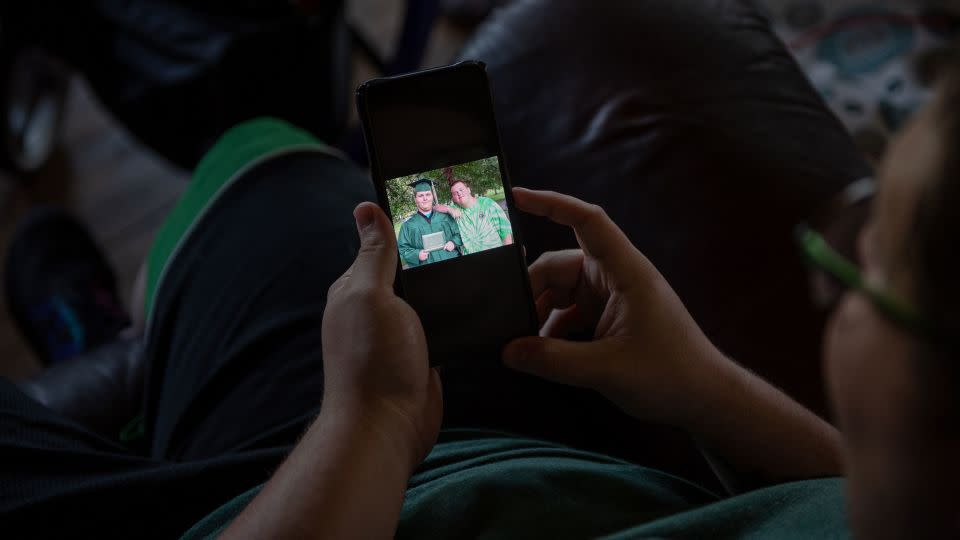 Cody Perkins shows a picture of himself and his younger brother, Quinn, on his phone. - Will Lanzoni/CNN