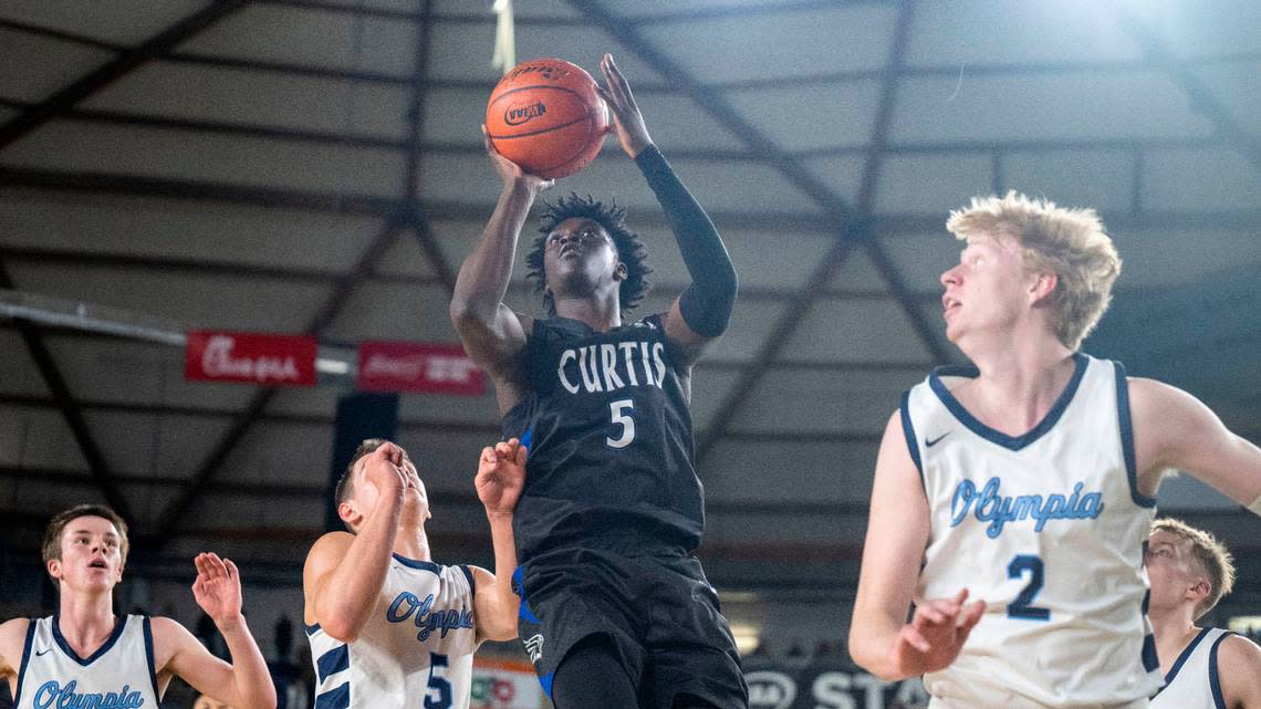 Curtis guard Zoom Diallo (5) attempts a jump shot while surrounded by Olympia defenders during the first quarter of the Class 4A championship game on Saturday, March 4, 2023, in Tacoma, Wash.