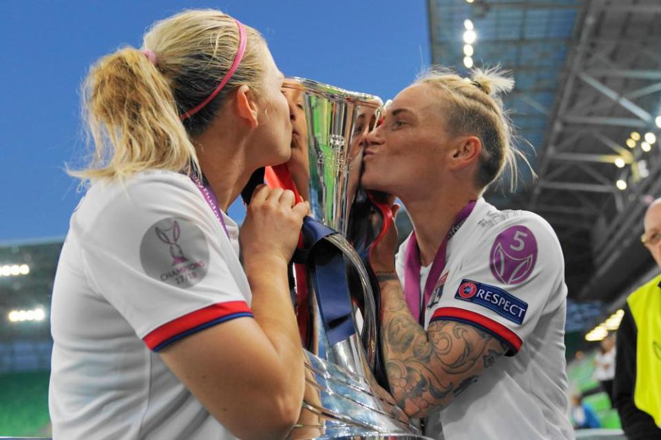 Lyon’s Jess Fishlock (right) and Eugénie Le Sommer kiss the Women’s Champions League trophy after the victory over Barcelona in May 2019.