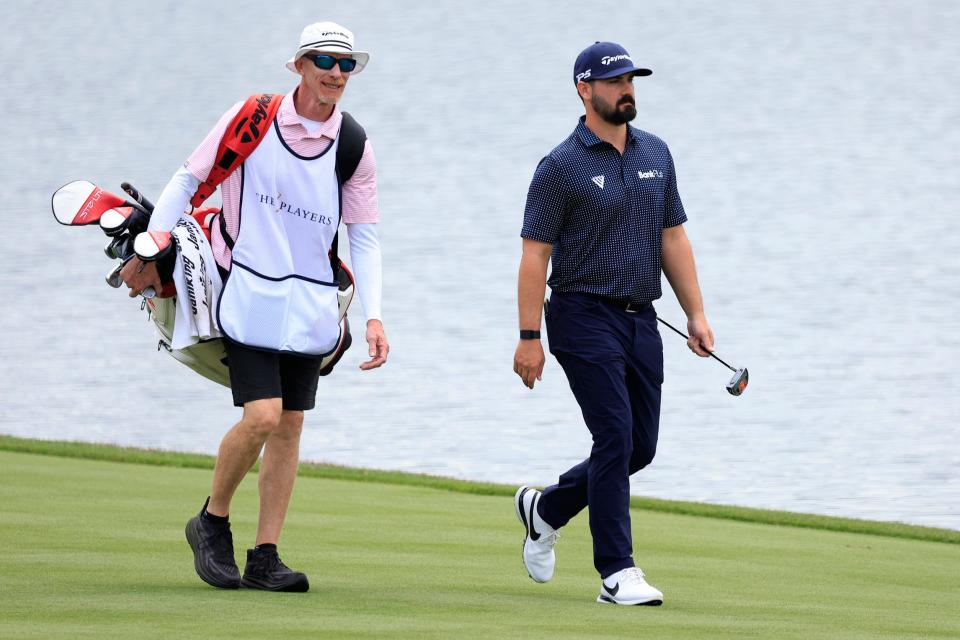 Chad Ramey walks down the 18th fairway of the Players Stadium Course with caddie Ryan Goble during the first round of The Players Championship.