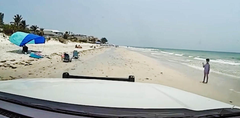 A sheriff's deputy approaches a lost girl on Indian Rocks Beach in Florida. (Pinellas County Sheriff's Office)