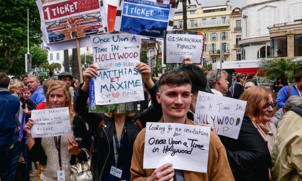 Festival goers hold up signs asking for invitations at the 72nd edition of the Cannes film festival