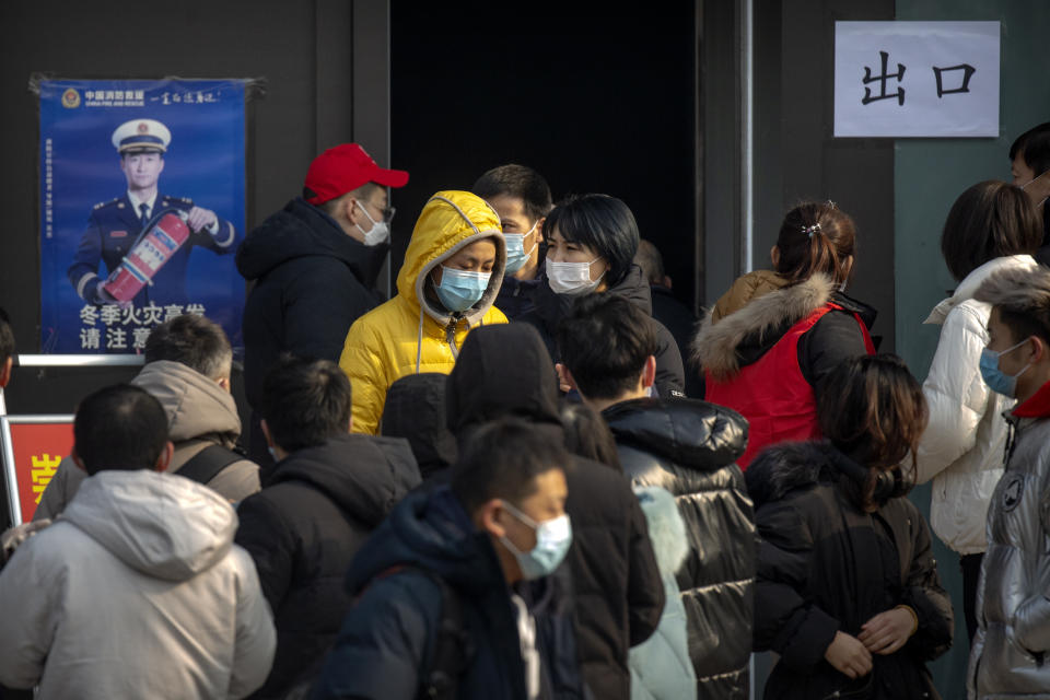 People wearing face masks to protect against the spread of the coronavirus walk out of a site for mass COVID-19 testing in a central district of Beijing, Friday, Jan. 22, 2021. Beijing has ordered fresh rounds of coronavirus testing for about 2 million people in the downtown area following new cases in the Chinese capital. (AP Photo/Mark Schiefelbein)