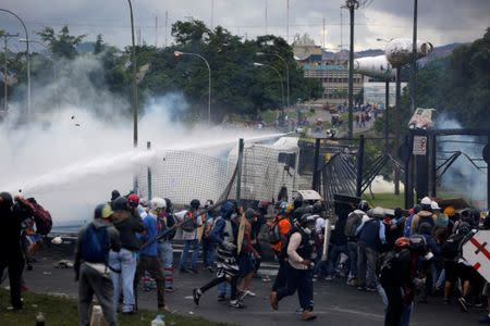 Demonstrators clash with riot security forces while rallying against Venezuelan President Nicolas Maduro's government in front of an Air Force base in Caracas, Venezuela, June 24, 2017. REUTERS/Ivan Alvarado