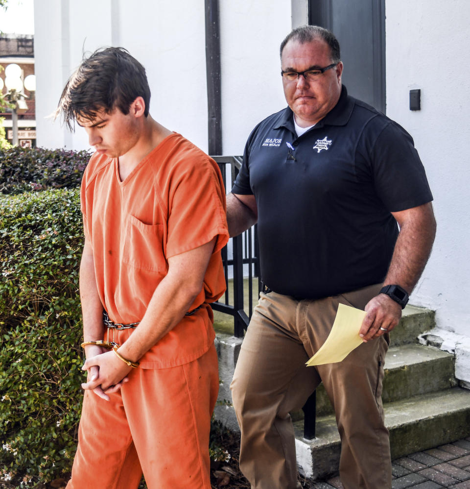 Brandon Theesfeld, left, is led from the Lafayette County Courthouse in Oxford, Miss., Tuesday, July 23, 2019, by Maj. Alan Wilburn, after being arraigned in connection with the death of 21-year-old University of Mississippi student Alexandria "Ally" Kostial. (Bruce Newman/The Oxford Eagle via AP)