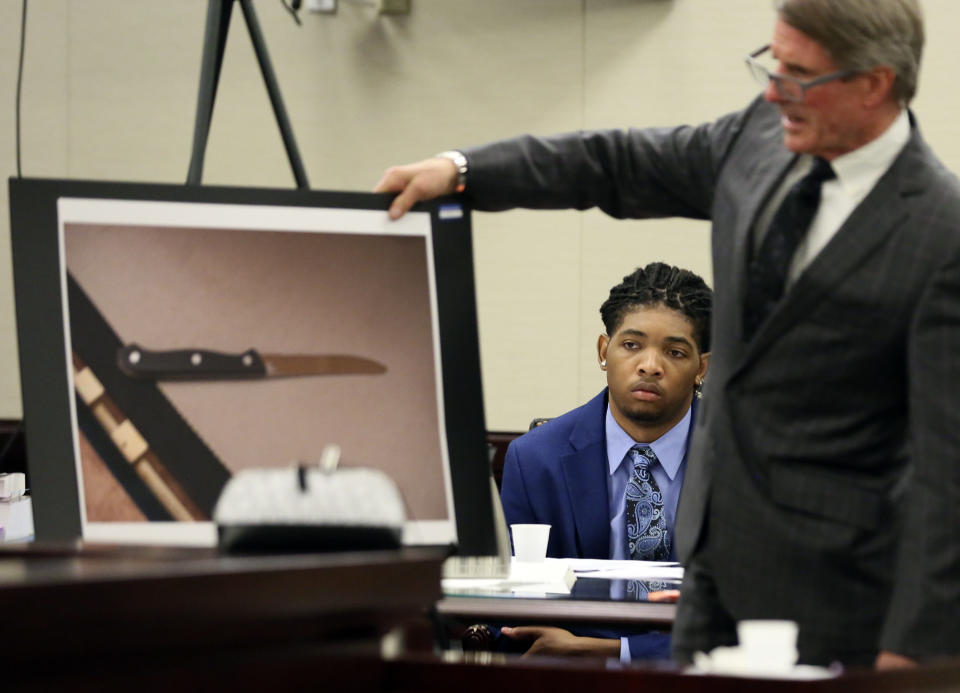 Isimemen David Etute looks on as his defense attorney Jimmy Turk presents a photograph of a knife that had been discovered at the crime scene in Montgomery County Circuit Court in Christiansburg, Va., Wednesday May 25 2022. (Matt Gentry/The Roanoke Times via AP, Pool)