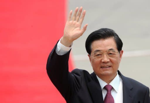 Chinese President Hu Jintao waves to the press after arriving at Hong Kong's International Airport on June 29. Hu has urged Hong Kong's restive people to embrace the motherland as he visited the financial citadel for the 15th anniversary of its return to rule by Beijing