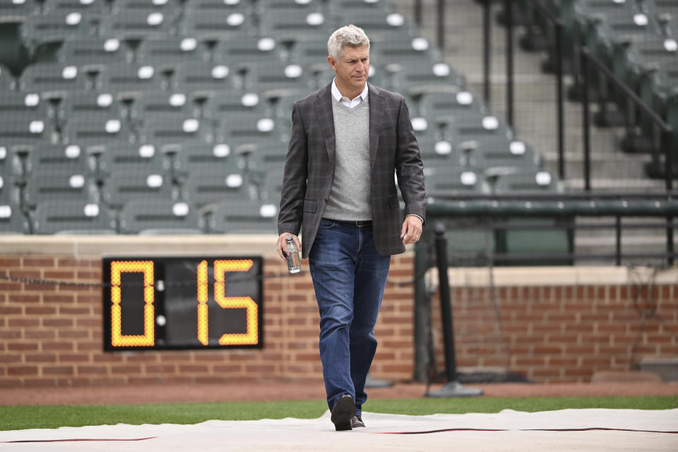 FILE - Baltimore Orioles general manager Mike Elias walks in front of a new pitching clock before a game against the New York Yankees on Saturday, April 8, 2023, in Baltimore. With a good deal of caution, Elias has indicated that yes, the Orioles would like to pursue contract extensions for some of their top young players. (AP Photo/Gail Burton, File)