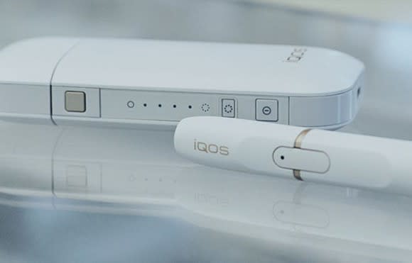 Philip Morris IQOS system, pictured in white, consists of a holder, charger, and a heat stick used to inhale the vapor.