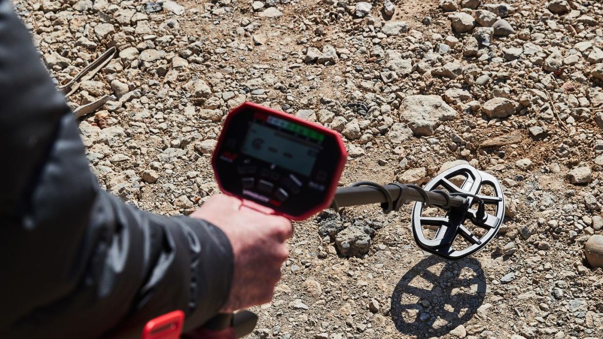 a person holding a metal detector