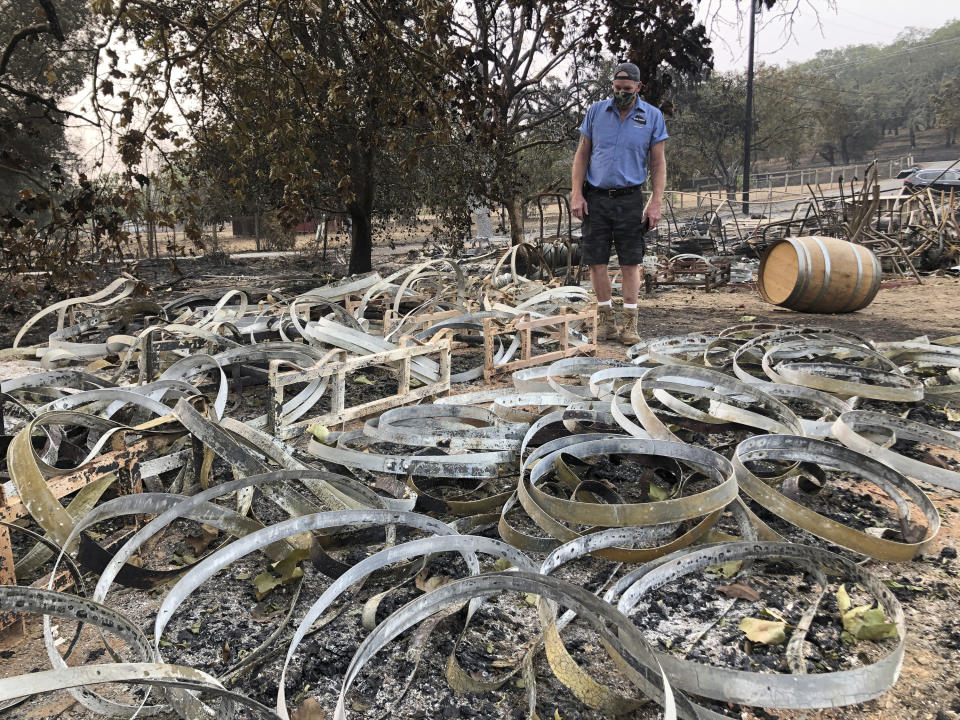 Kevin Conant looks down at hundreds of burnt metal rings left from burned wine barrels at his business "Conants Wine Barrel Creations," after the Glass/Shady fire completely engulfed it in Santa Rosa, Calif., Wednesday, Sept. 30, 2020. The Conants escaped with their lives, which we are grateful for, but they barely made it out with the clothes on their backs in the wake of the fire. The Glass and Zogg fires are among nearly 30 wildfires burning in California. (AP Photo/Haven Daley)