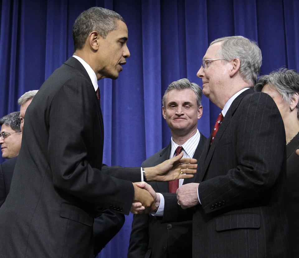 President Barack Obama, left, shakes hands with Senate Republican Leader Mitch McConnell, R-Ky., right, after signing the $858 billion tax deal into law in a ceremony in the Eisenhower Executive Office Building on the White House complex, Friday, Dec. 17, 2010 in Washington.  