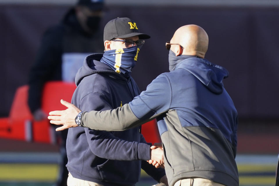 Michigan head coach Jim Harbaugh, left, greets Penn State head coach James Franklin after an NCAA college football game, Saturday, Nov. 28, 2020, in Ann Arbor, Mich. Penn State won 27-17. (AP Photo/Carlos Osorio)