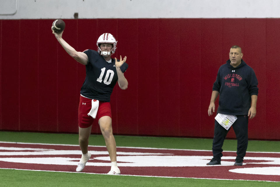 Wisconsin quarterback Tyler Van Dyke (10) makes a pass in front of Wisconsin offensive coordinator Phil Longo during spring NCAA college football practice at the McClain Center in Madison, Wisc., Thursday, April 4, 2024.(Samantha Madar/Wisconsin State Journal via AP)