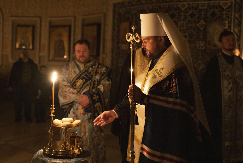 Metropolitan Oleksandr (Drabynko) delivers a religious service with clerics inside the Transfiguration of Jesus Orthodox Cathedral during a blackout caused by recent Russian rocket attacks, in Kyiv, Ukraine, Saturday, Dec. 3, 2022. (AP Photo/Efrem Lukatsky)