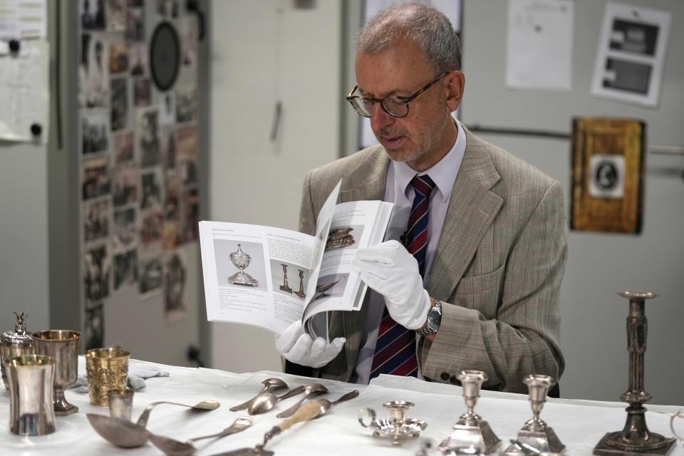 Matthias Weniger, curator of the Bavarian National Museum, shows a catalogue of silver objects stolen by the Nazis from the Jews during the Third Reich, in Munich, Germany, Saturday, June 10, 2023. Museum staff have made it their mission to return as many of the silver objects as possible to the descendants of the original owners. (AP Photo/Matthias Schrader)