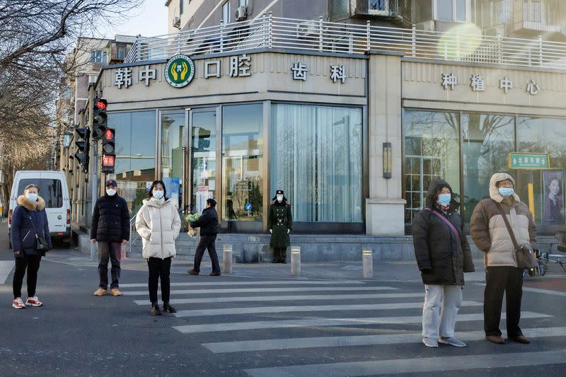 Un miembro de las Fuerzas Armadas Populares de China lleva una mascarilla mientras vigila en una calle en medio de los brotes de la enfermedad del coronavirus (COVID-19) en Pekín, China