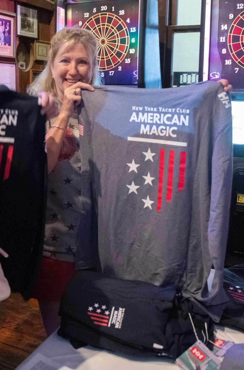 Karen Kriegel picks up some American Magic gear during a watch party at Seville Quarter on Friday, Sept. 15, 2023. Dozens of sailing enthusiasts gathered at the downtown Pensacola entertainment complex for a watch party featuring the sailing team competing in Vilanova i la Geltru, Spain.