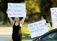 <p>Angelina Lazo (L), an 18-year-old senior at Marjory Stoneman Douglas High School, who said that she lost two friends in the shooting at her school two days ago, reacts to honks of support from passing motorists as she and her mother, Linda Lazo (R), join other gun control proponents with placards at a street corner in Coral Springs, Fla., Feb. 16, 2018. (Photo: Jonathan Drake/Reuters) </p>