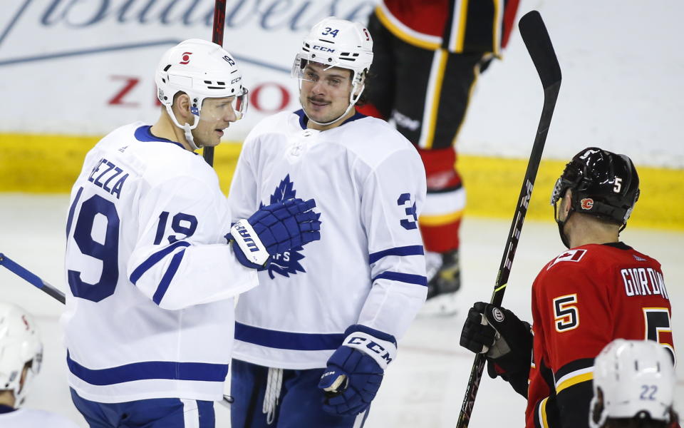 Toronto Maple Leafs' Auston Matthews, center, celebrates his goal with teammate Jason Spezza during third-period NHL hockey game action in Calgary, Alberta, Sunday, Jan. 24, 2021. (Jeff McIntosh/The Canadian Press via AP)