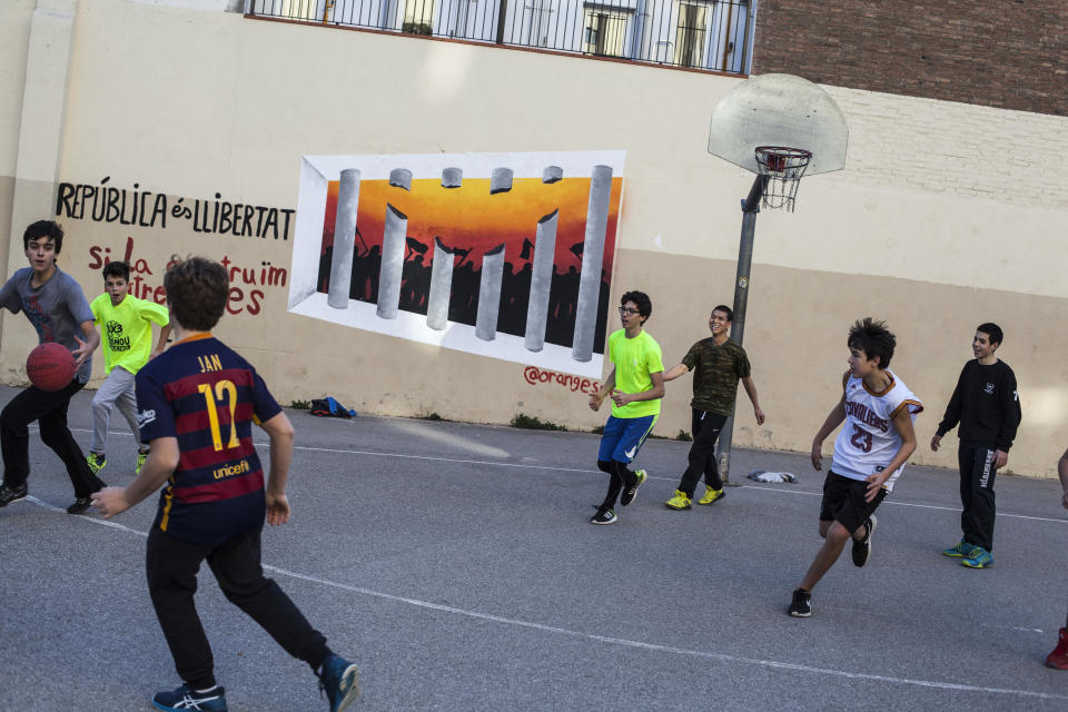 <p>A group of young people plays basketball against the background of a painting of support for detained pro-independence prisoners in Barcelona, Spain, Dec. 21, 2017. (Photograph by Jose Colon / MeMo for Yahoo News) </p>