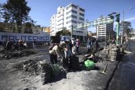 Volunteers help to clean up streets in the aftermath of violent protests against the government, in Quito, Ecuador, Monday, Oct. 14, 2019. Ecuador celebrated a deal President Lenín Moreno and indigenous leaders struck late Sunday to cancel a disputed austerity package and end nearly two weeks of protests that have paralyzed the economy and left seven dead. (AP Photo/Fernando Vergara)