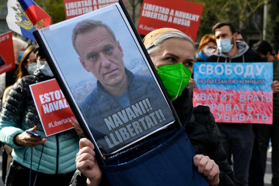 A woman holds a picture of detained Russian opposition leader Alexei Navalny reading 