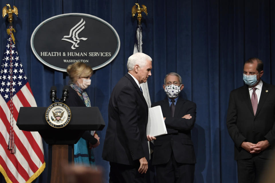 Vice President Mike Pence, second from left, walks off of the stage following the conclusion of a briefing with the Coronavirus Task Force at the Department of Health and Human Services in Washington, Friday, June 26, 2020. Dr. Deborah Birx, left, Dr. Anthony Fauci, second from right, and Health and Human Services Secretary Alex Azar, right, follow Pence. (AP Photo/Susan Walsh)