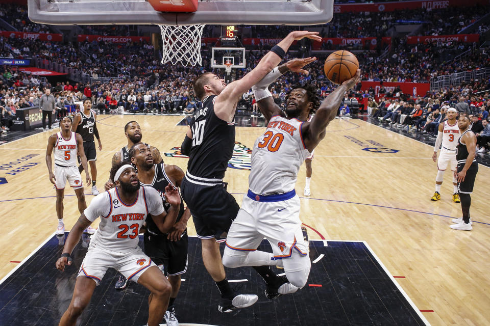 New York Knicks forward Julius Randle (30) shoots under pressure from Los Angeles Clippers center Ivica Zubac (40) during the second half of an NBA basketball game Saturday, March 11, 2023, in Los Angeles. (AP Photo/Ringo H.W. Chiu)
