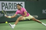 Carlos Alcaraz, of Spain, returns a shot to Felix Auger-Aliassime, of Canada, at the BNP Paribas Open tennis tournament Thursday, March 16, 2023, in Indian Wells, Calif. (AP Photo/Mark J. Terrill)