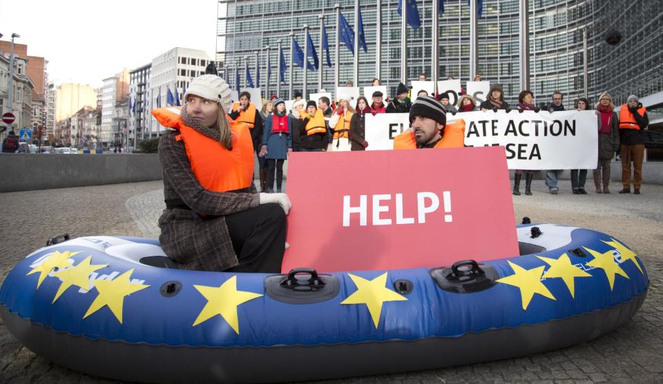 Protestors from Friends of the Earth hold up cards during a demonstration outside EU headquarters in Brussels on Wednesday, Jan. 22, 2014. The European Commission on Wednesday proposed a framework for climate and energy policies beyond 2020 and up to 2030. (AP Photo/Virginia Mayo)