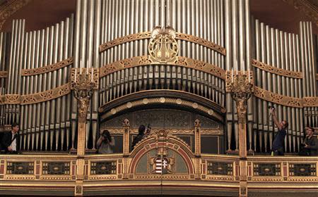 People take photographs of the pipe organ in the reopened large concert hall of the Liszt Academy music school in Budapest October 21, 2013. REUTERS/Laszlo Balogh