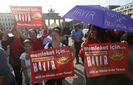 People hold banners calling Turkish voters to vote "no" on the upcoming referendum as they attend an anti-Turkish President Tayyip Erdogan prostest in front of the Brandenburg Gate in Berlin, Germany, April 1, 2017. REUTERS/Fabrizio Bensch