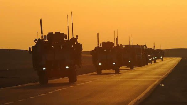 PHOTO: A convoy of armored vehicles drive toward Camp Beuhring, Kuwait, in 2011. (DOD/108th Public Affairs Detachment)