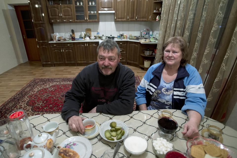 In this photo taken Thursday, March 27, 2014 Crimea's Tatar Setyaya Murtazayev, 64, and his Russian wife Galina sit at the table inside their long-standing squatter settlement in Pionerskoye, not far from Simferopol, Crimea. On Saturday the Crimean Tatar Qurultay, a religious congress will determine whether the Tatars will accept Russian citizenship and the political system that comes with it, or remain Ukrainian citizens on Russian soil. (AP Photo/Pavel Golovkin)