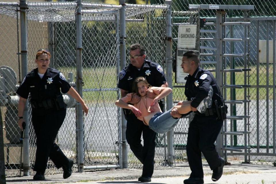 A California student being carried away by police officers during a drill