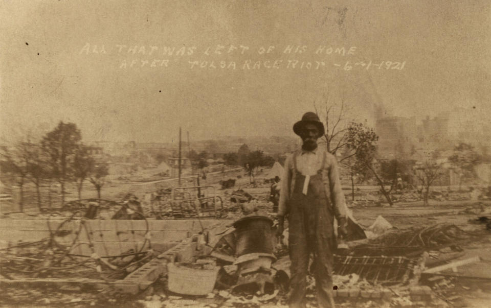 This photo provided by the Department of Special Collections, McFarlin Library, The University of Tulsa shows an unidentified man standing alone amid the ruins of what is described as his home in Tulsa, Okla., in the aftermath of the June, 1, 1921, Tulsa Race Massacre. (Department of Special Collections, McFarlin Library, The University of Tulsa via AP)