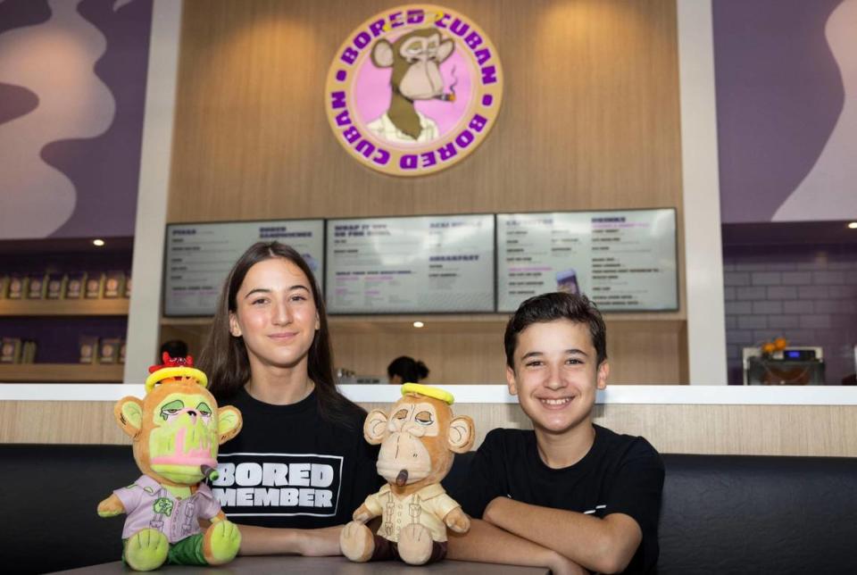 Ale Castellanos, 14, and Nico Castellanos, 13, pose with the plushies they helped design at Bored Cuban restaurant in Miami.