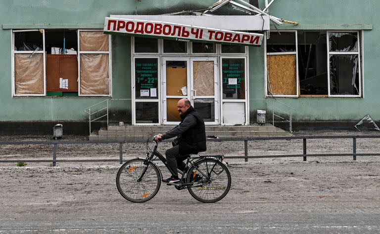 Un hombre pasa en bicicleta por delante de un edificio destruido en Balakliia, región de Kharkiv, el 10 de septiembre de 2022, en medio de la invasión rusa de Ucrania.