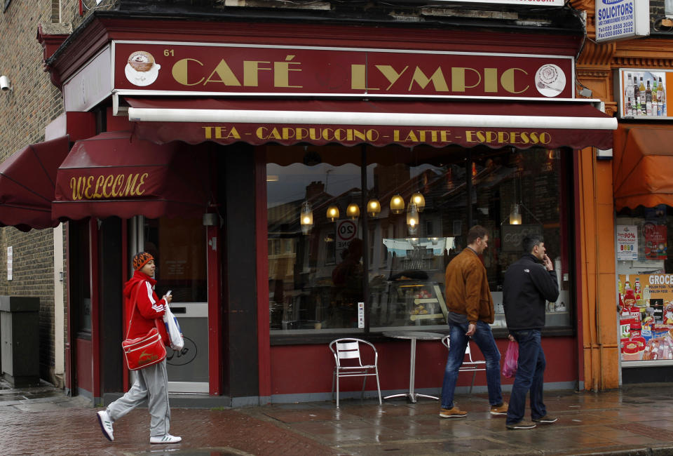 In this Friday, April 27, 2012 photo people walk past the Cafe Lympic in Stratford, east London. One day, the small espresso shop near the site of the London Games was the "Olympic" cafe. The next day, it was the "Lympic." So where did the "O" go? The manager won't say. But it's more than likely the small business became another casualty in the battle against guerrilla marketers _ advertisers who try to associate their products with an event without paying to be sponsors. Protecting the Olympic brand is always a big job, and never more so than this year. Olympic organizers say the increasing sophistication of guerrilla marketers and the rise of social media are putting the five rings under assault in ways barely envisioned a decade ago. (AP Photo/Matt Dunham)