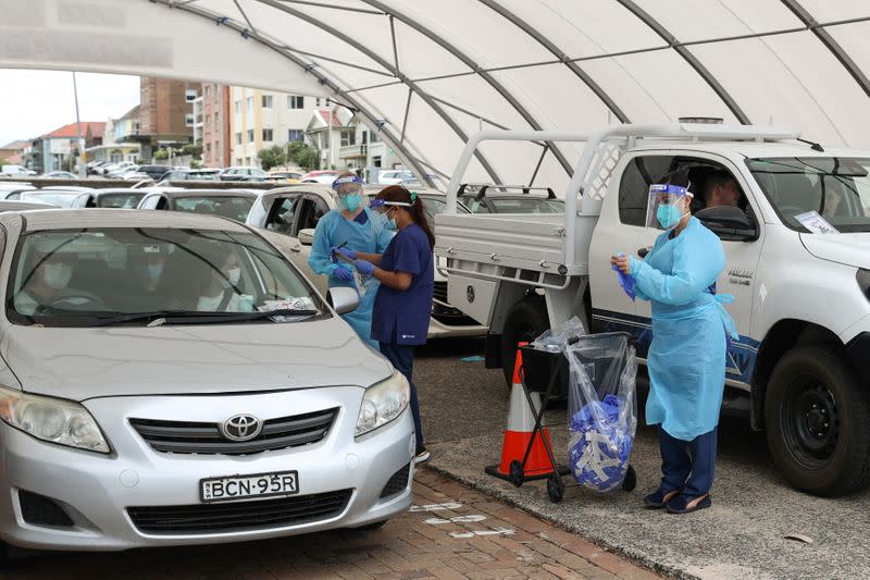 Medical workers administer tests at a drive-through COVID-19 testing centre in Sydney