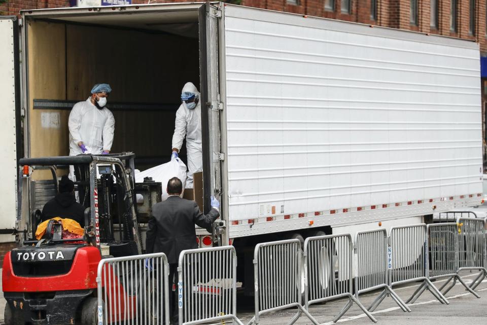 <span class="caption">A body being loaded onto a refrigerated container truck used as a temporary morgue in New York in March.</span> <span class="attribution"><a class="link " href="https://newsroom.ap.org/detail/VirusOutbreakNewYork/cdc500f7a9a1401bbb7f3c2b3ba773e0/photo?Query=covid%20refrigerated%20trucks&mediaType=photo&sortBy=&dateRange=Anytime&totalCount=26&currentItemNo=14" rel="nofollow noopener" target="_blank" data-ylk="slk:AP Photo/John Minchillo;elm:context_link;itc:0;sec:content-canvas">AP Photo/John Minchillo</a></span>