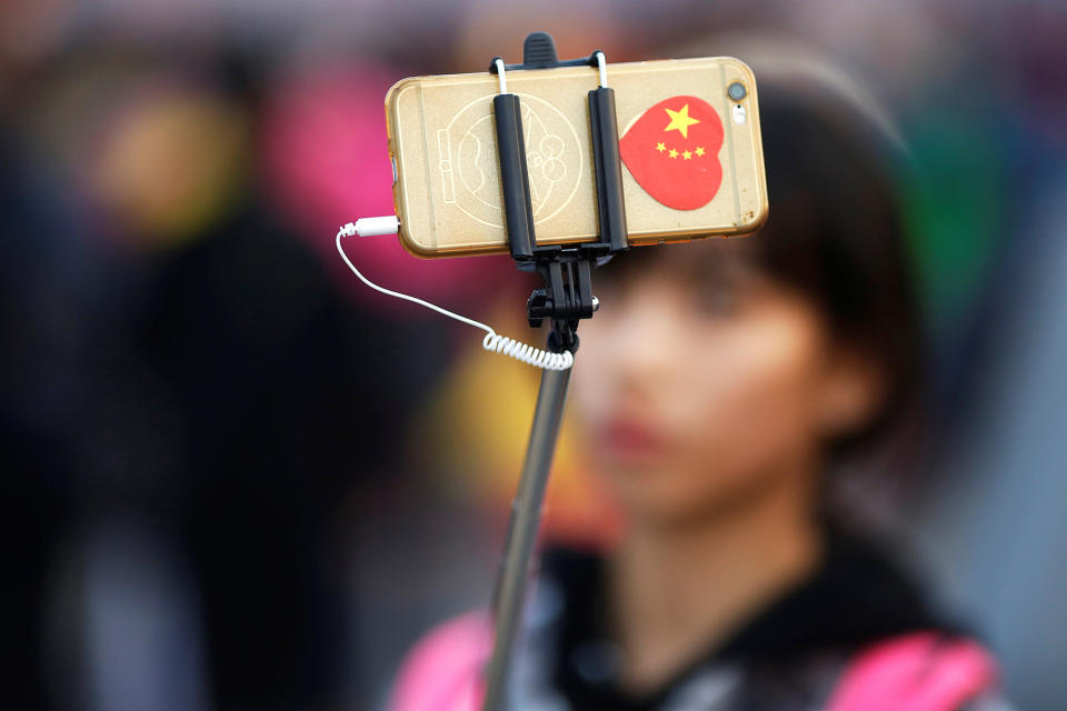 <p>A woman takes pictures of herself as people gather in Tiananmen Square to celebrate National Day marking the 67th anniversary of the founding of the People’s Republic of China, in Beijing October 1, 2016. (REUTERS/Damir Sagolj) </p>