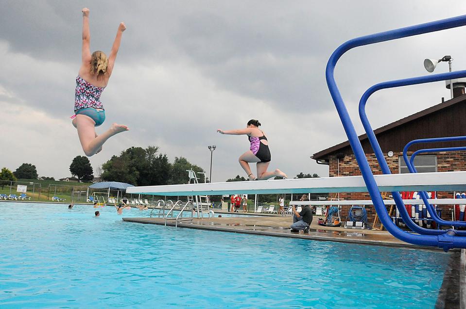 Kids hop off the diving board during a free swimming event at the Loudonville pool in 2015. The pool is closed this season while the village seeks a new manager after Cheryl Young abruptly resigned Friday over a disagreement with swim team parents. FILE PHOTO/ASHLAND TIMES-GAZETTE