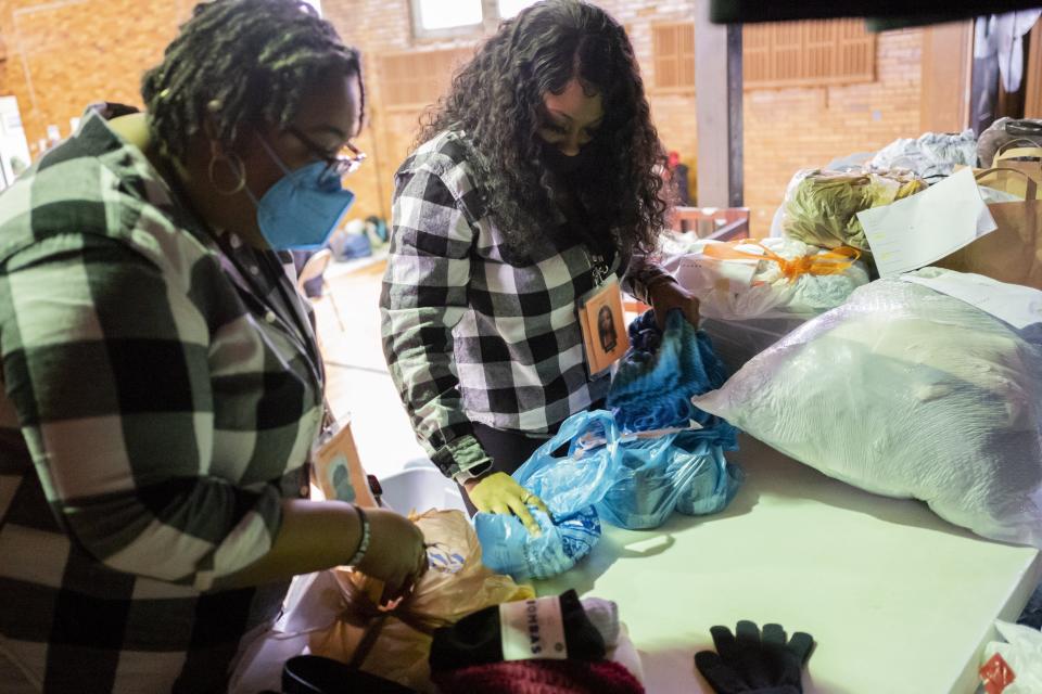 Angeleila Watkins, center, and Jess Smiley, left, both community health workers with the Columbus Coalition for the Homeless, sort clothes for distribution while at a warming station at the Broad Street United Methodist Church.