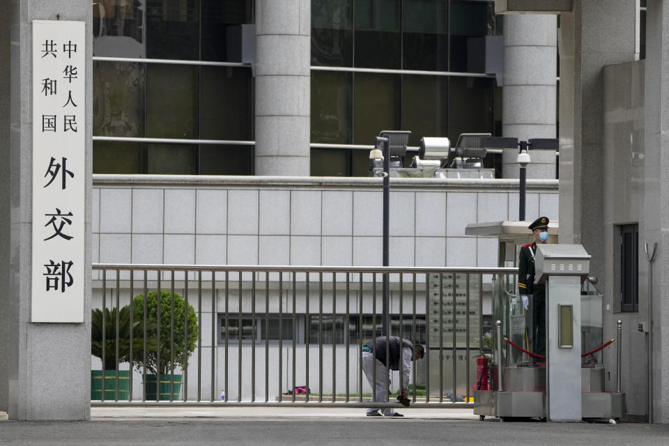 A paramilitary policeman stands watch as a worker wipes the main entrance gate of the Ministry of Foreign Affairs office in Beijing, Monday, April 24, 2023. The Chinese government said Monday it respects the sovereignty of former Soviet Union republics after Beijing’s ambassador to France caused an uproar in Europe by saying they aren’t sovereign nations. (AP Photo/Andy Wong)