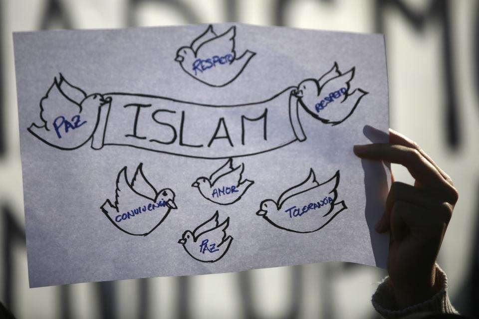 Girl holds up a sign during a rally by members of the Muslim community of Madrid outside Madrid's Atocha train station