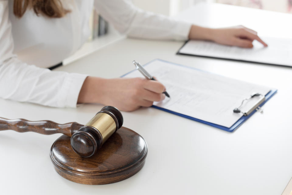 Woman at a desk with a gavel and legal documents