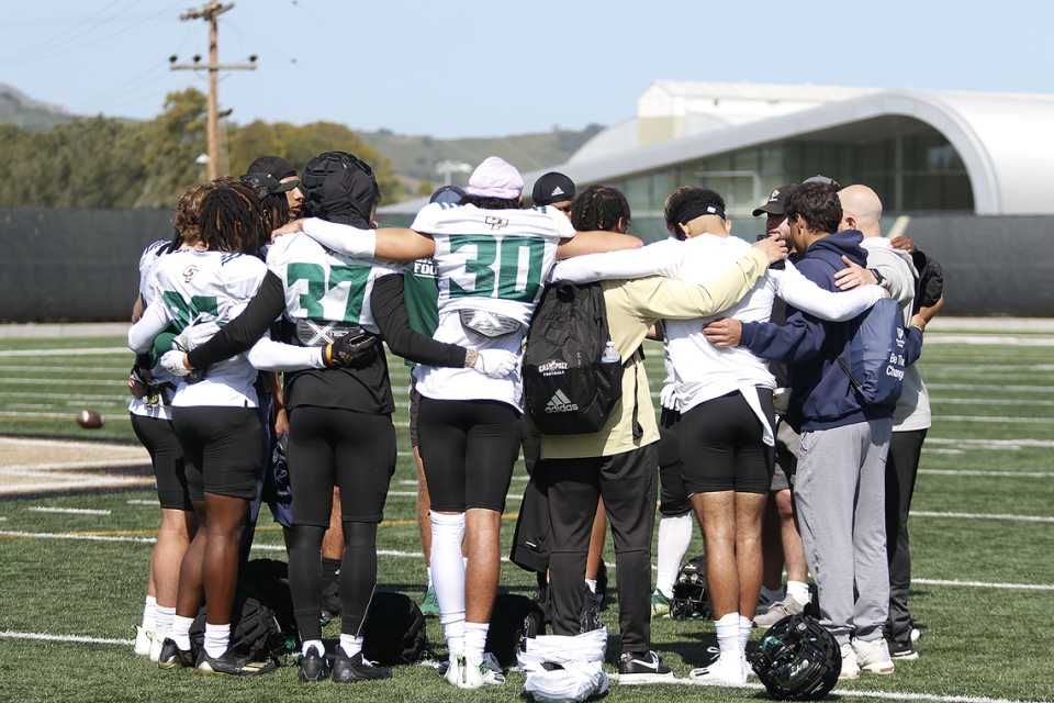 Players gather for a huddle during the Cal Poly football team’s spring practices at Doerr Family Field on April 14, 2023.