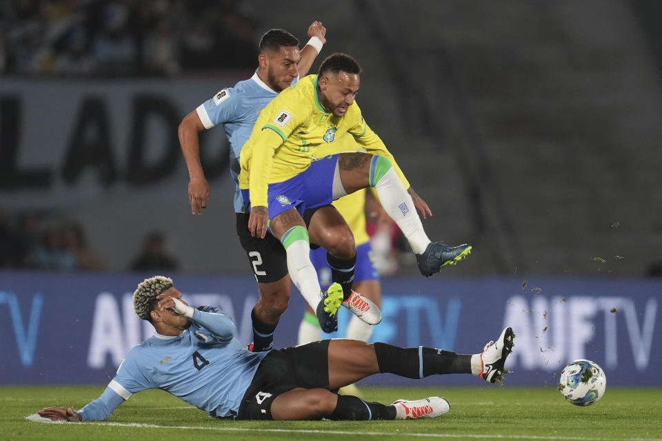 Brazil's Neymar is tackled by Uruguay's Ronald Araujo, on the ground, during a qualifying soccer match for the FIFA World Cup 2026 at Centenario stadium in Montevideo, Uruguay, Tuesday, Oct. 17, 2023. (AP Photo/Matilde Campodonico)